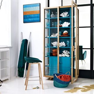 white wall room with blue storage unit and wooden frame and wooden design chair