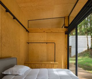 timber clad bedroom with large window at Casa El Pinar