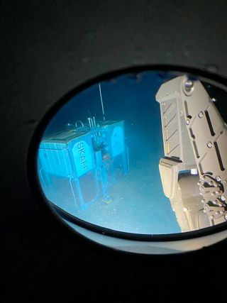 The view at the bottom of Challenger Deep, looking out from the "Limiting Factor" submersible at the automated lander "Skaff" and the "Raptor" hydraulic manipulator, June 7, 2020.