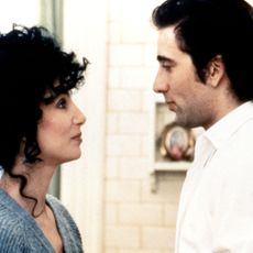 cher and nic cage smile at each other in a still from moonstruck