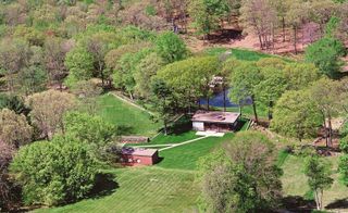 Aerial view of the estate in 1990, with paths leading from the parking area on the left to the Glass House and Brick House; the pavillion on the pond and the Monument to Lincoln Kirstein tower in the woodland can also be seen