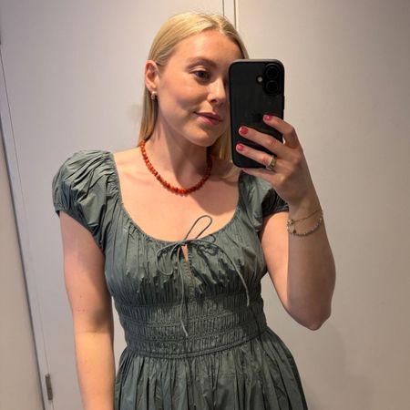 Woman wears green D&ocirc;en dress, red necklace