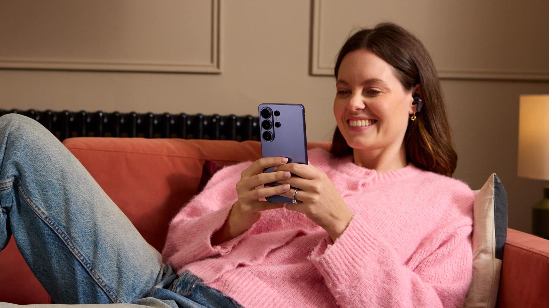 A person using the Samsung Galaxy S26 Ultra while sitting on the sofa