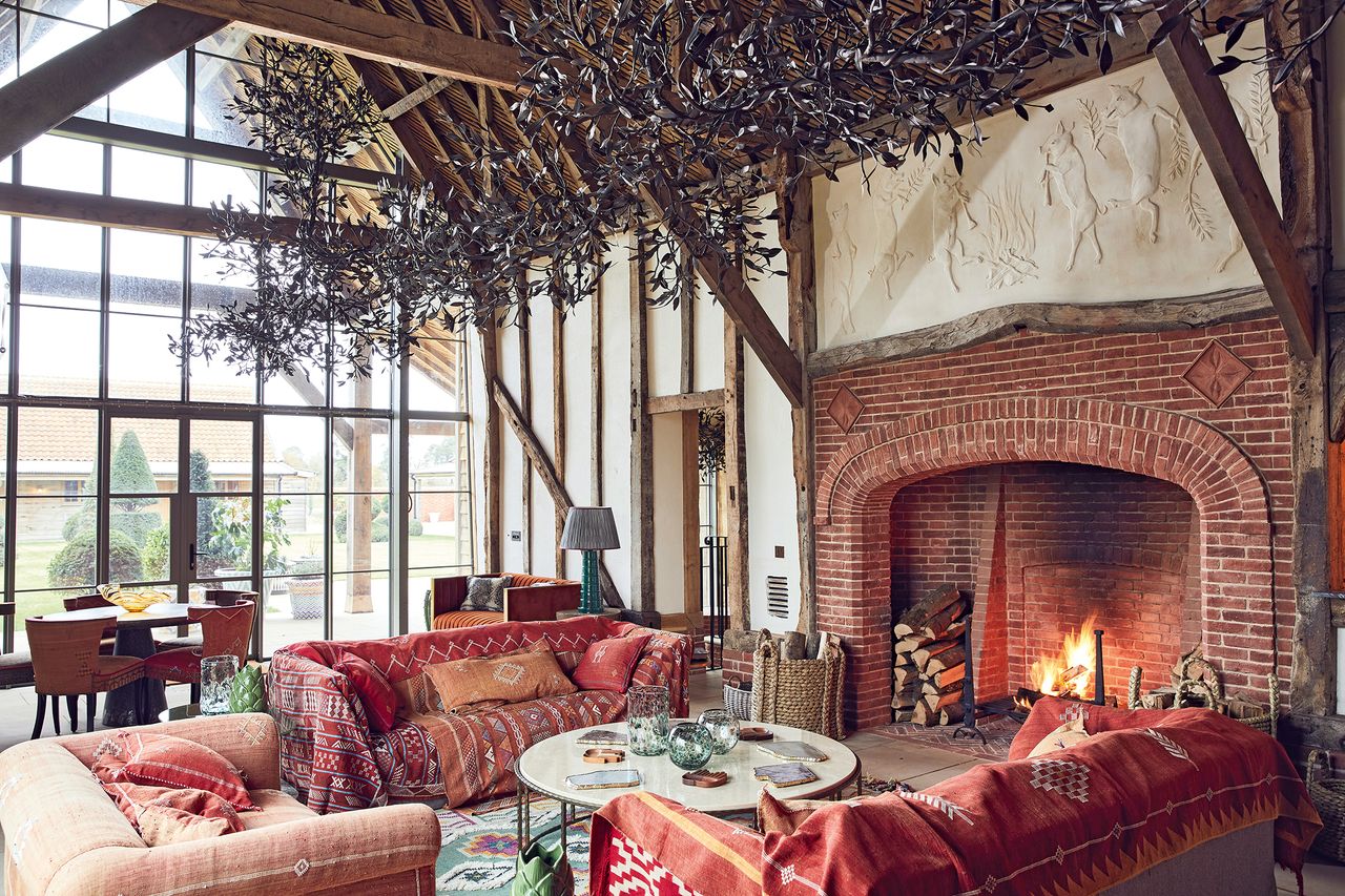 Wilderness Reserve, Suffolk. The restored Suffolk long barn is dominated by a 45ft olive-branch chandelier designed and crafted by Cox London and a decorative plasterwork panel.