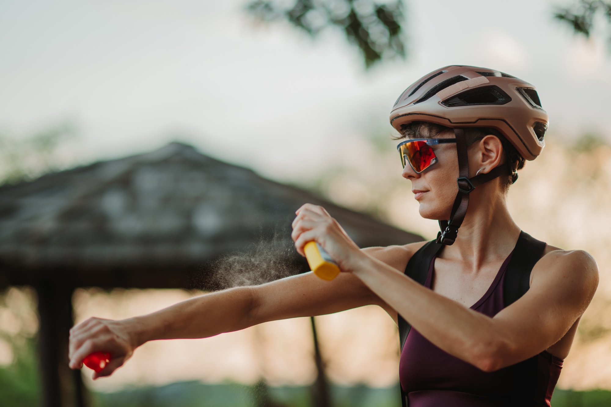 Image of a cyclist putting on sunscreen