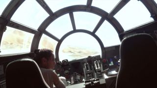 Rey flying the Millennium Falcon from inside the cockpit in Star Wars: The Force Awakens