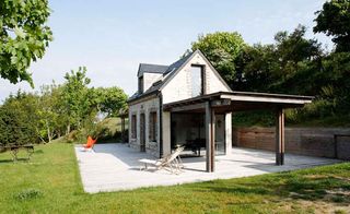 Daytime, outside image of VW House by Franklin Azzi, patio area, reclining chairs, grass lawn, trees, blue sky