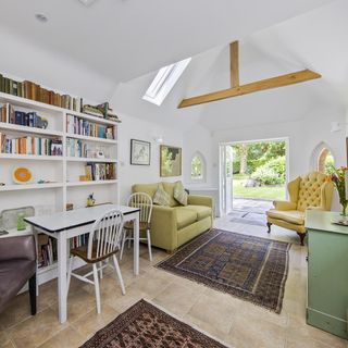 living and dining area with white wall and sofa and yellow arm chair and white dining table and chair and book shelves