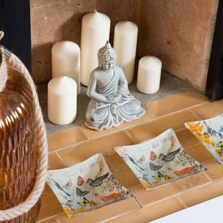 buddha statue with white candles and plates