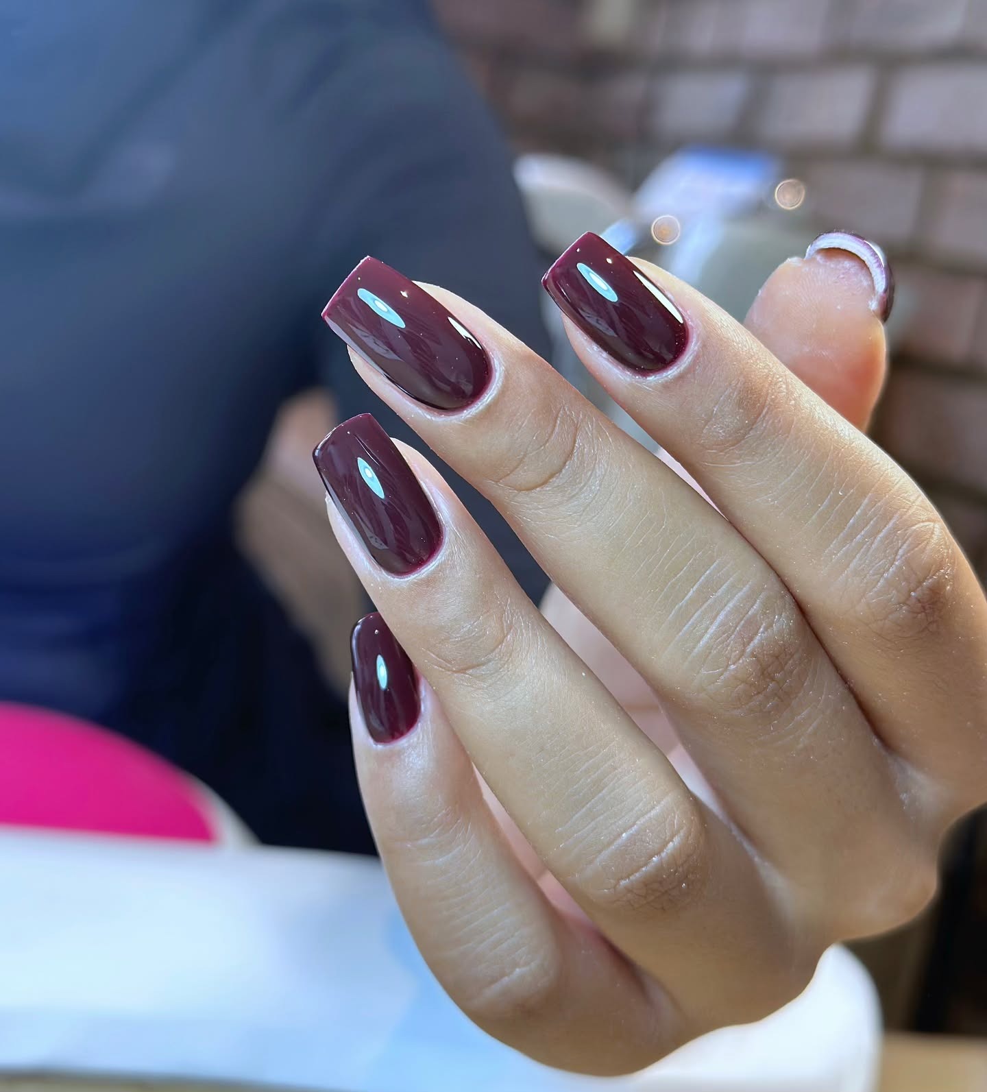 A long, square-shaped aubergine manicure