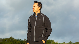 A golfer wears the Original Penguin Earl Full Zip Waterproof Jacket