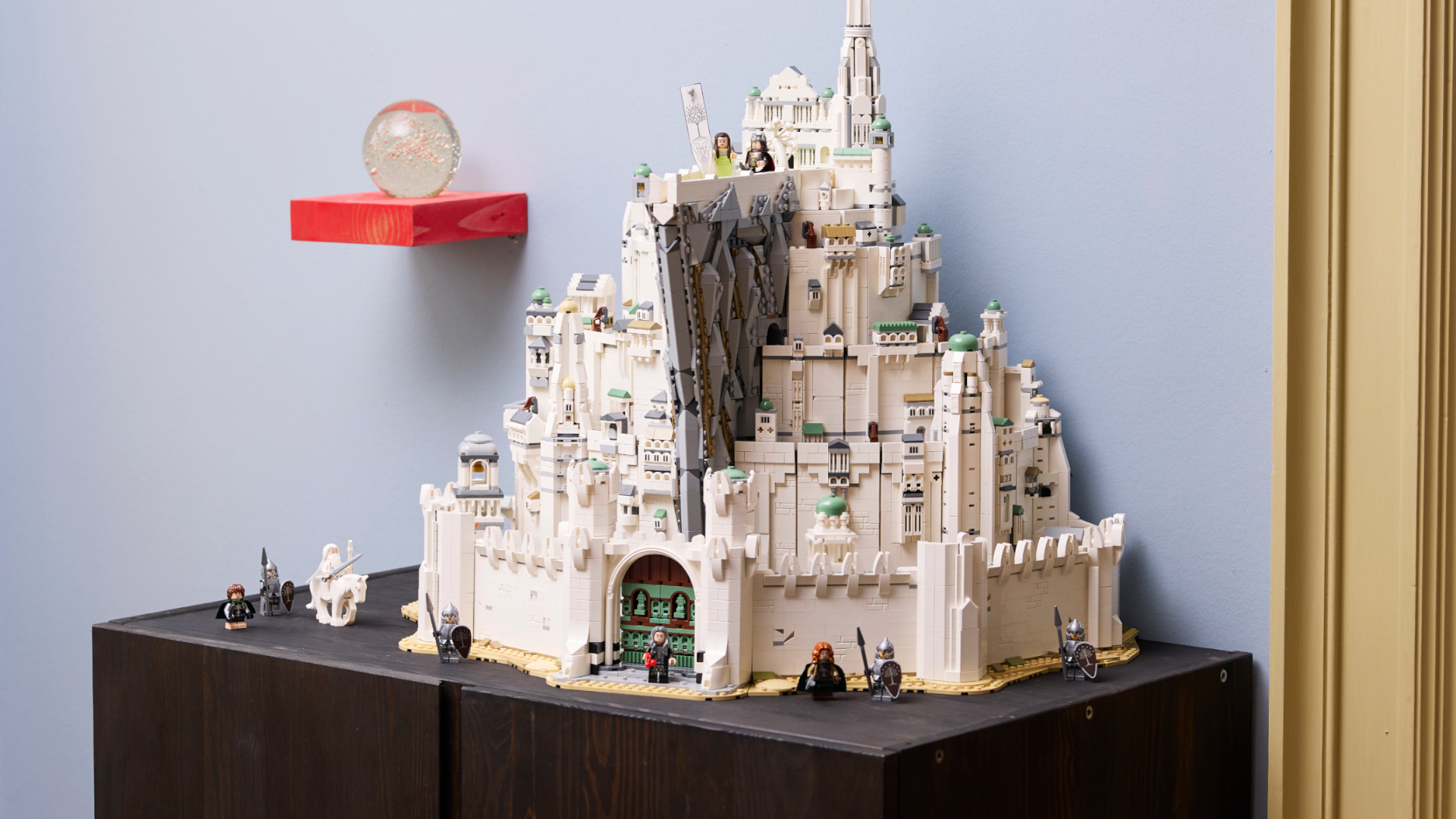 Lego Minas Tirith on a wooden surface, with multiple minifigures visible
