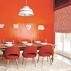 room with orange wall white wooden door and dining table with chairs