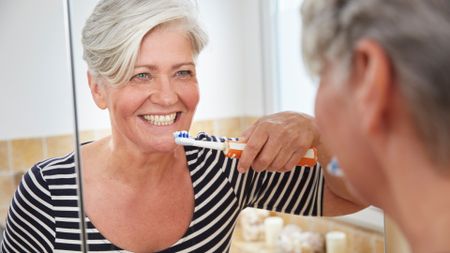 Woman brushing her teeth with electric toothbrush