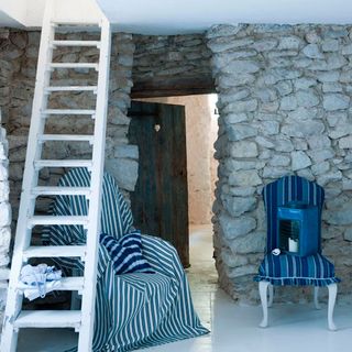 white living space with stoned wall and blue chair