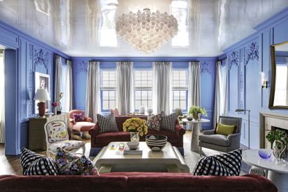 blue living room using gloss paint on the walls with red sofas 