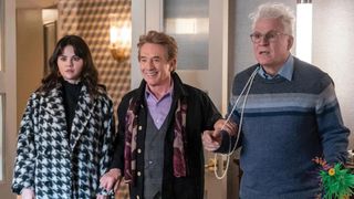 Selena Gomez, Martin Short and Steven Martin stand in shock, with a necklace over Steve's right shoulder.