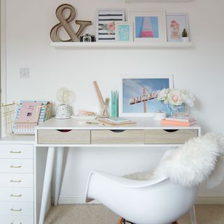 white bedroom with wall shelf and desk