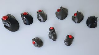 An overhead shot of many different models of trackball mice on a desk