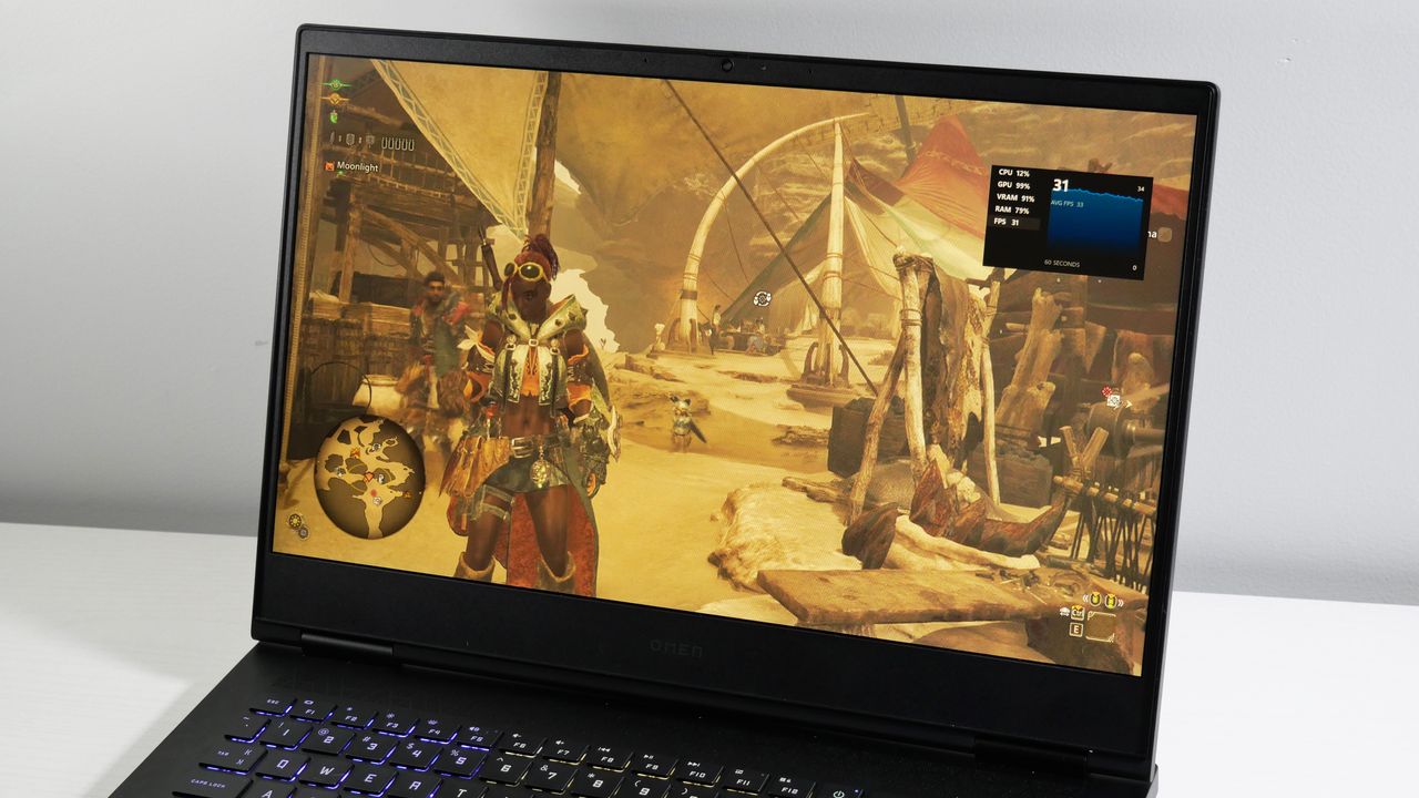 HP Omen 16 open on a white desk with Monster Hunter Wilds playing on screen.