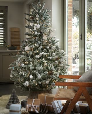 Frosted Christmas tree with white decorations in living room