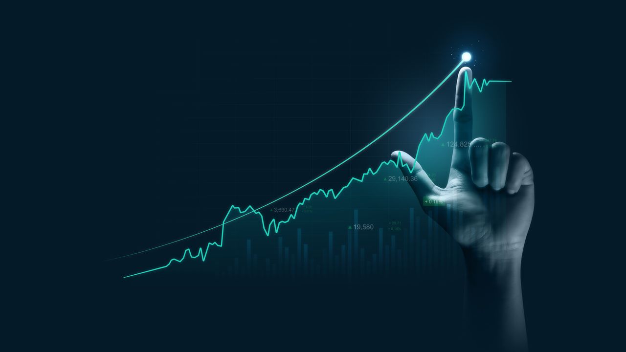 Virtual hand in the metaverse, pointing to an upward-trending share price chart