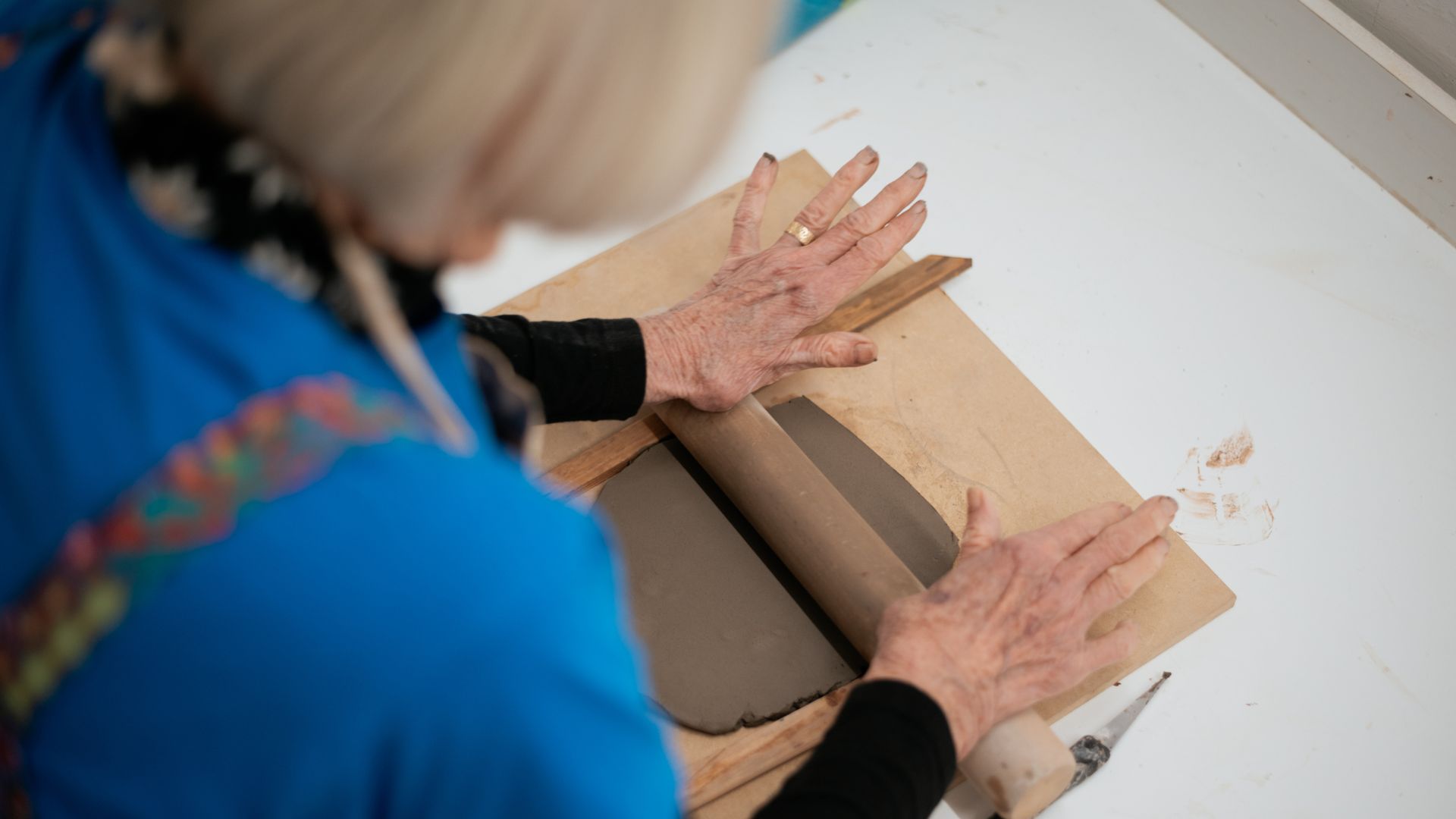 Masters student Judith Potter, age 79, rolling sculptors clay