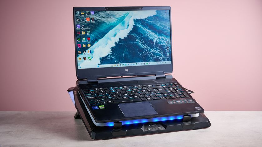 An Acer Predator Helios 300 laptop sat on top of the Klim Mistral laptop cooling pad in front of a pink background.