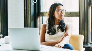 Woman gazing out the window at desk