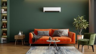 Air conditioner in green living room with orange sofa