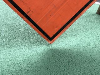 Orange sign on green pavement