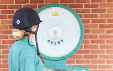 A rider weighing themselves on scales