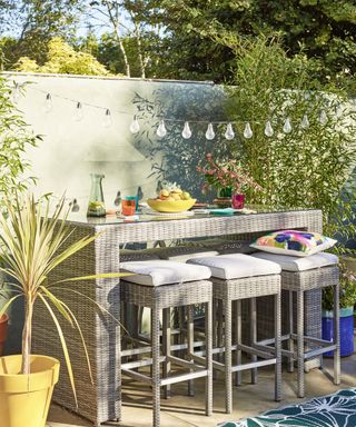 garden bar with stools and drinks with festoon lighting above
