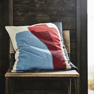 Ikea cushion cover with wooden chair and wooden panelled wall