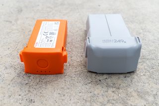 The DJI Mavic Mini 3 Pro battery next to the Autel EVO Nano+ battery on a concrete surface