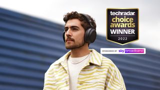 Sennheiser Momentum 4 Wireless getragen von einem Mann im Freien mit TechRadar Choice Awards Winner Logo