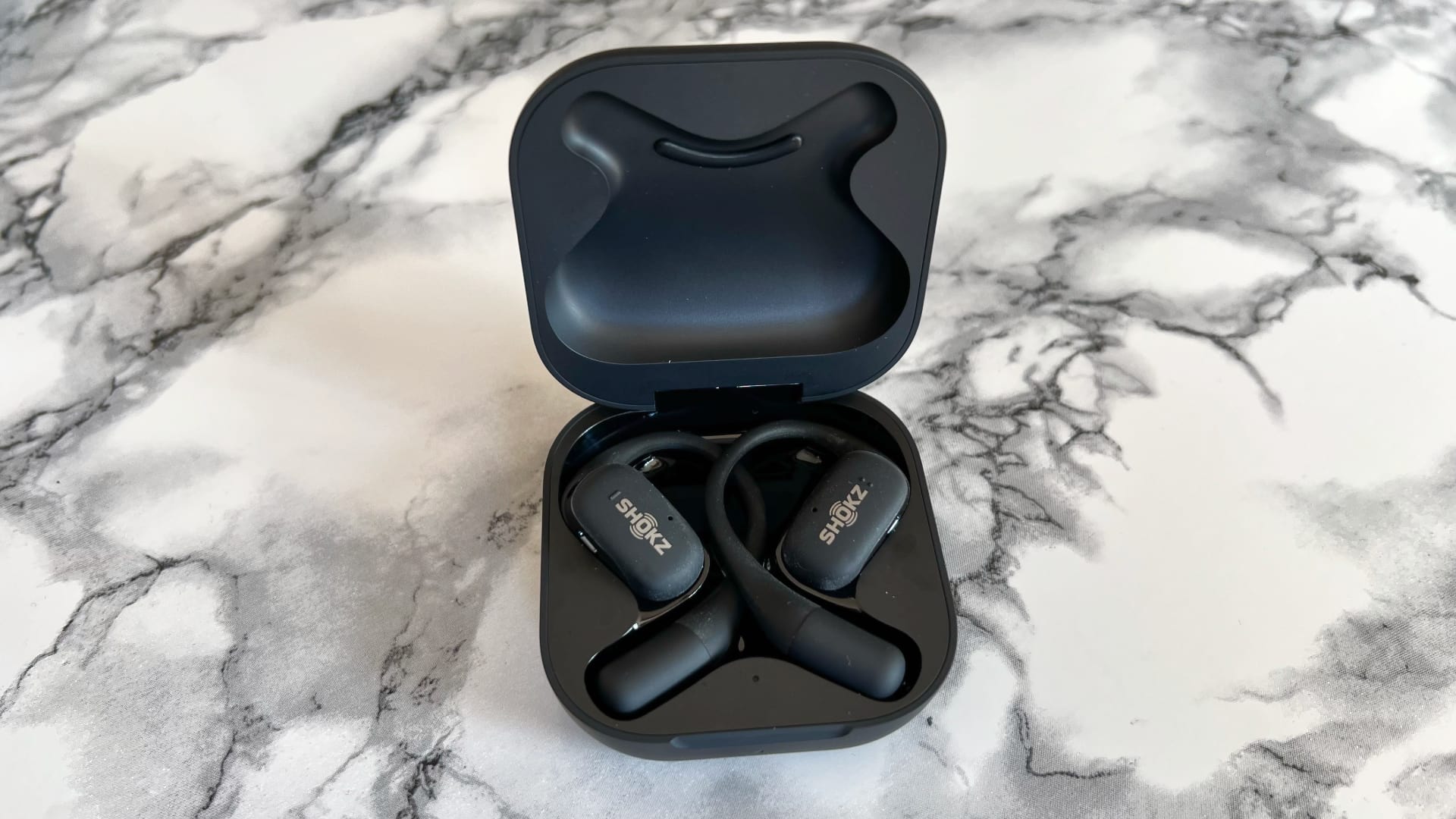 Shokz openfit mot marmorerat bord