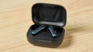 A photo of the EarFun Air Pro 4 earbuds in their case on a wooden surface