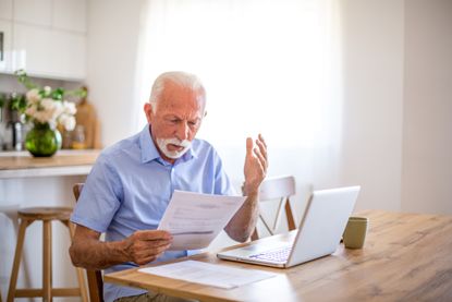 a pic of a man surprised reading a bill