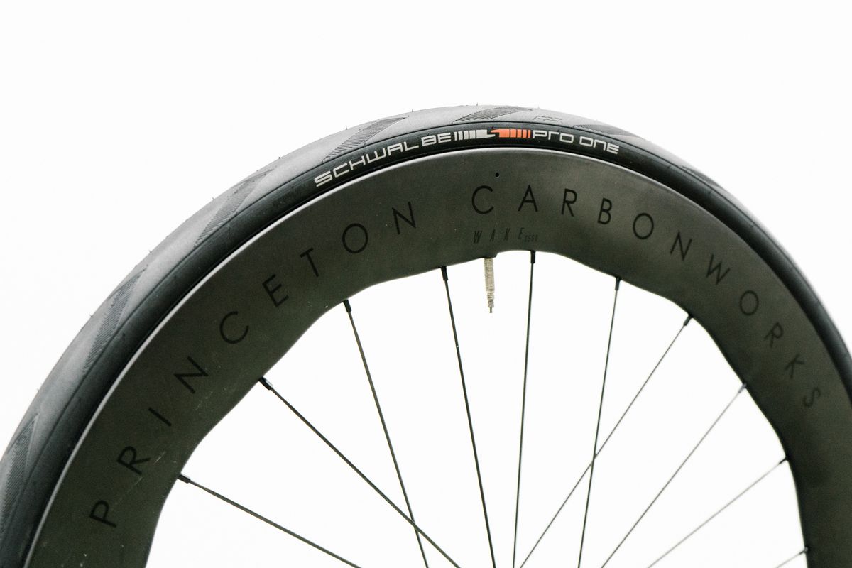 An aero road wheel stands against a white wall