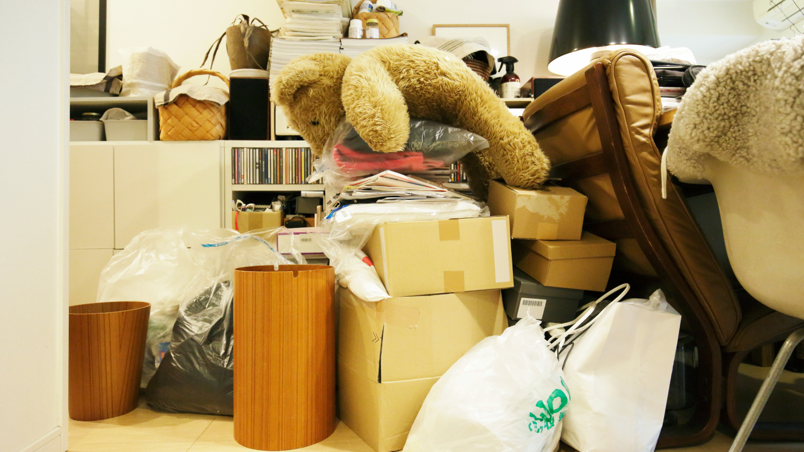 piles of boxes, belongings, furniture and bags in a room
