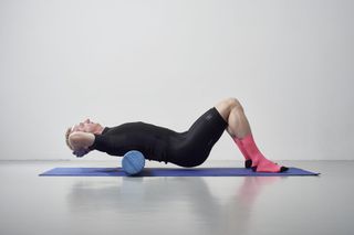 Male cyclist using a foam roller to ease his shoulder pain from cycling