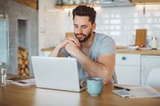 Young man worried about his finances at home.