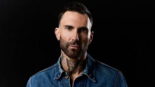 Adam Levine appears in front of a black background in an NBC media photo from The Voice Season 29.