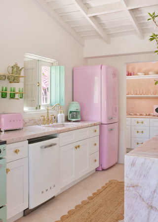 A small, pink quartzite kitchen with matching pink smeg appliances