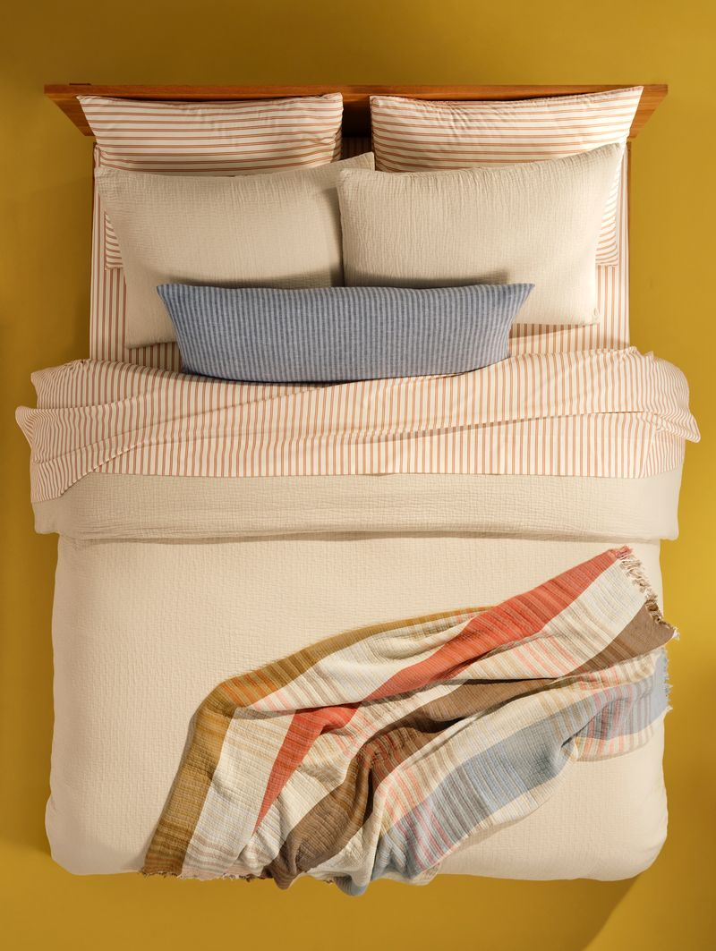 Striped Brooklinen bed sheets pictured from a bird's eye view