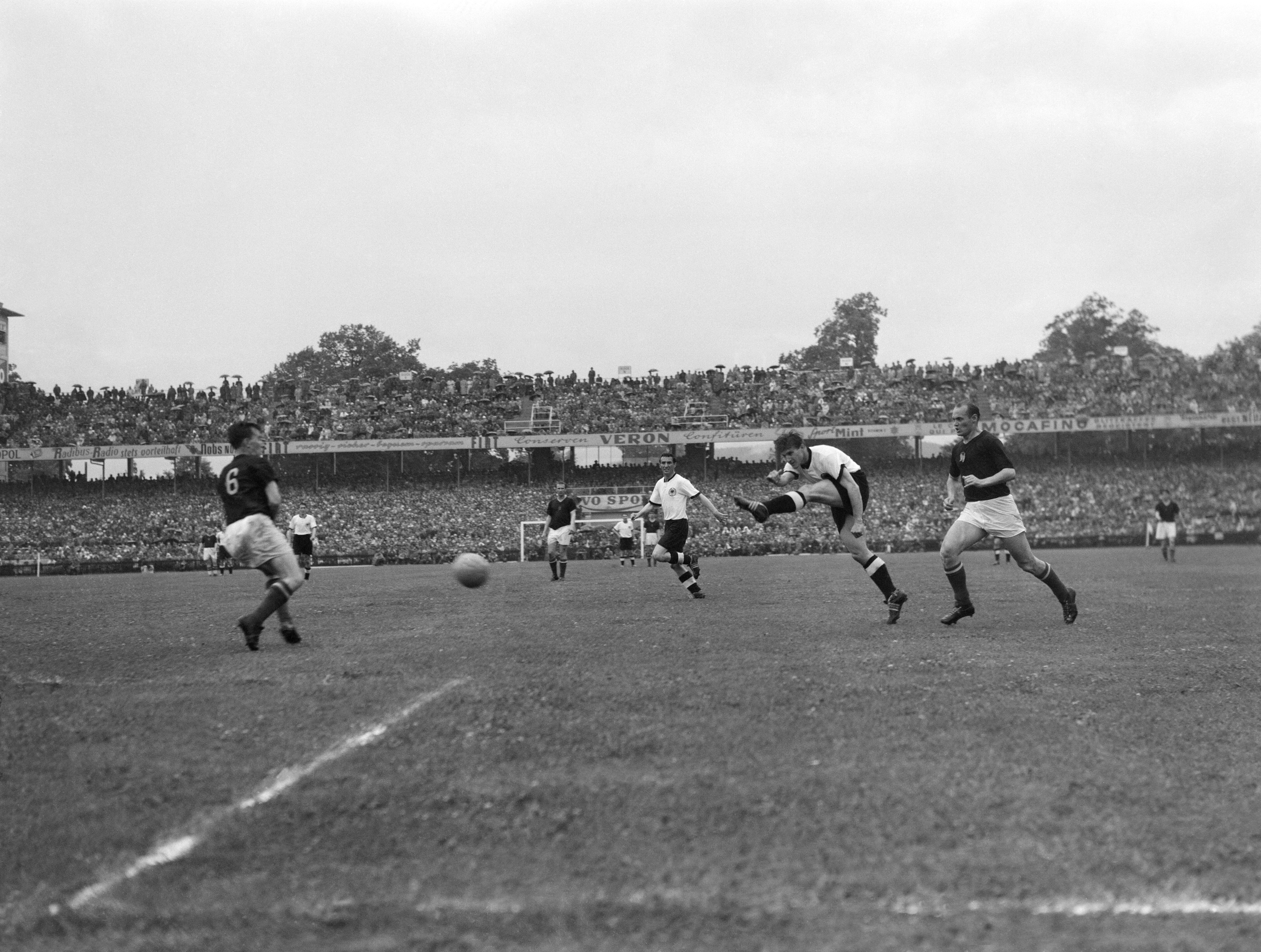 BERNA, SUÍÇA - 4 DE JULHO: Fritz Walter, da Alemanha Ocidental, atira em direção ao gol enquanto Gyula Lorant (R) da Hungria faz um desafio durante a final da Copa do Mundo FIFA de 1954 entre a Alemanha Ocidental e a Hungria