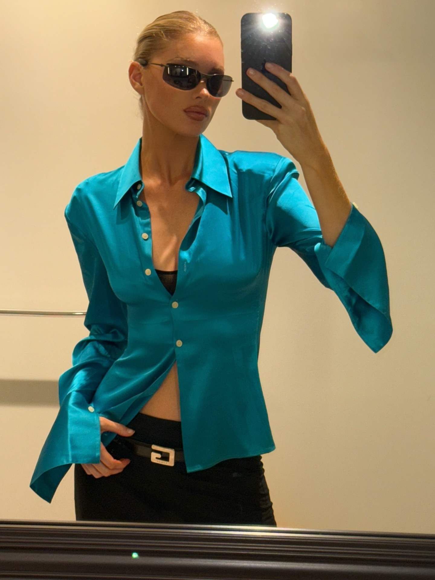 Influencer Elsa Hosk wears a blue satin shirt with a black pencil skirt