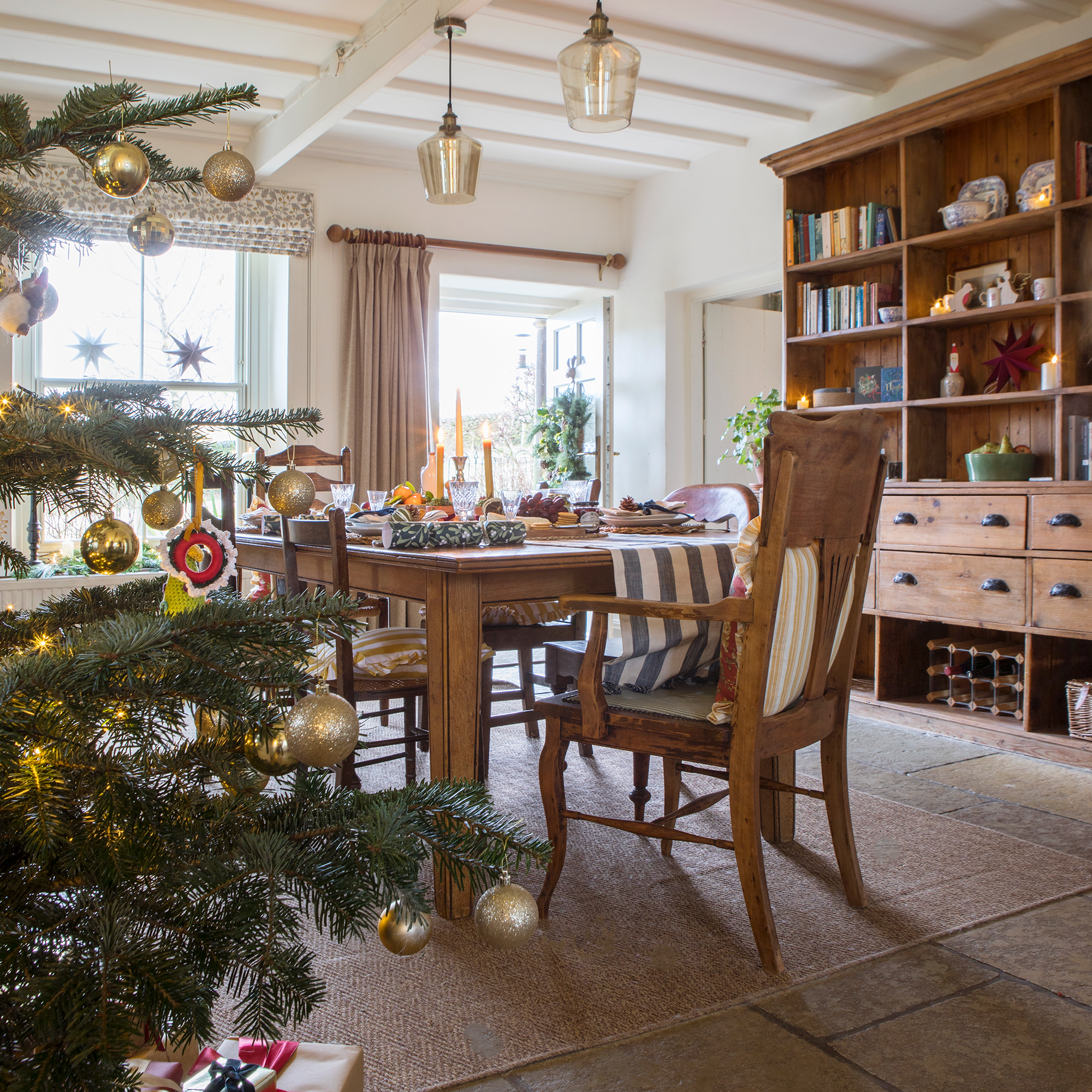 rustic dining room in a farmhouse with a dresser and wooden table dressed for Christmas