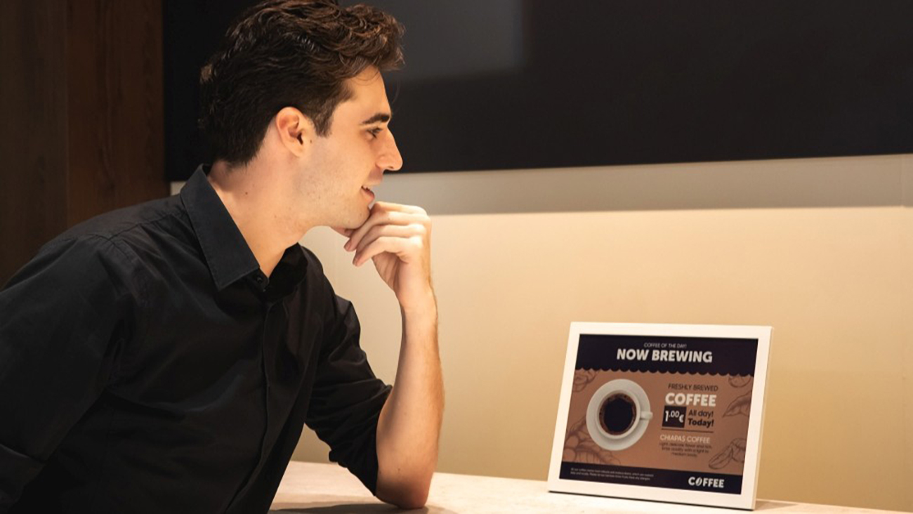 A man looking at an e-paper display, which is made from bioplastic. (The man is presumably also organic.)